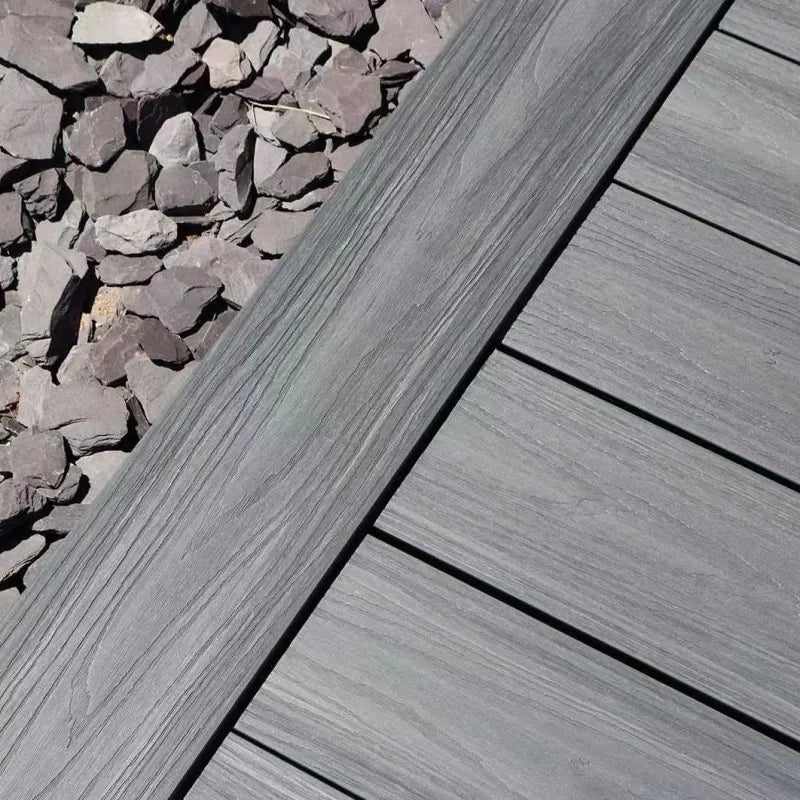Grey composite decking boards laid diagonally beside slate chippings