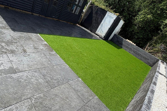 An artificial lawn laid against paving in a domestic garden